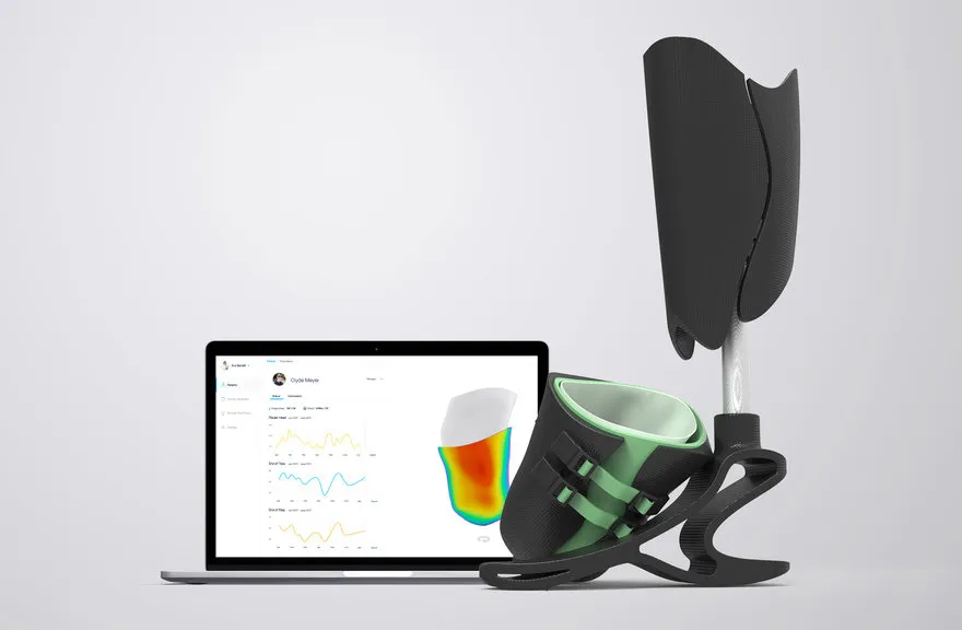 Prosthetic socket beside a laptop showing pressure-mapping software